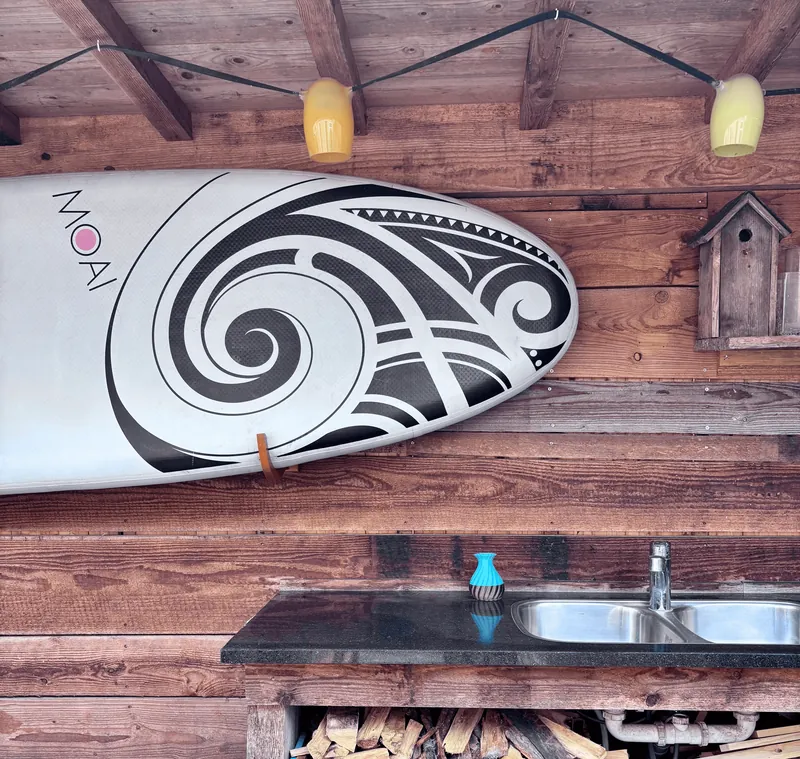 SUP-plank aan de houten wand van het buitenplaatsje