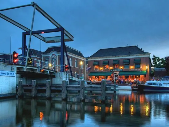 De ophaalbrug en een verlicht restaurant aan het water in de avond