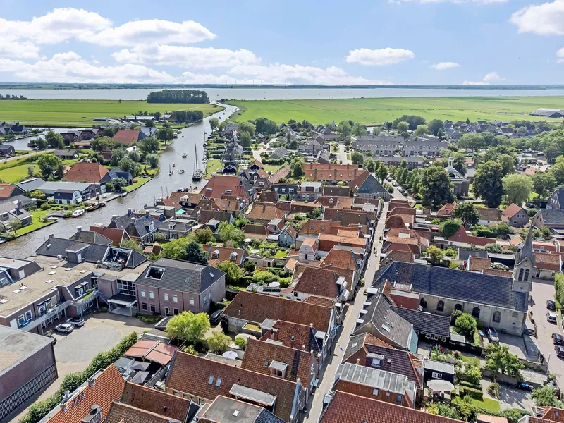 Luchtfoto van Woudsend met de vaart en de kerk