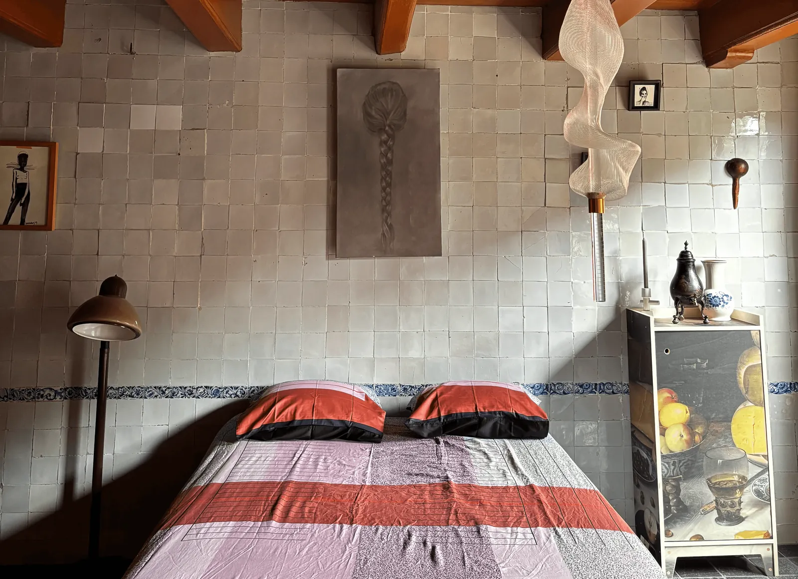 Slaapkamer met tegelwand en houten plafondbalken