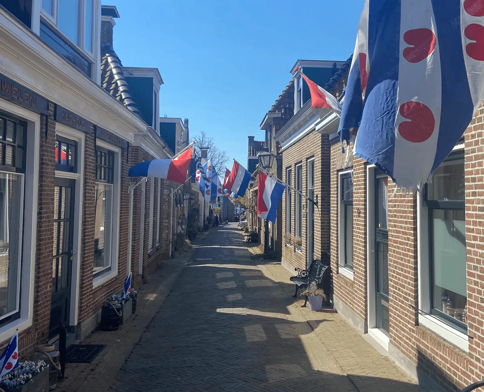 Steegje in Woudsend met vlaggen aan de gevels