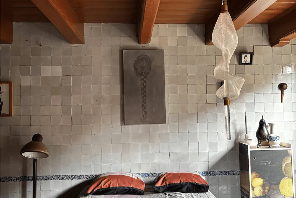 Slaapkamer met tegelwand en een lamp aan de muur